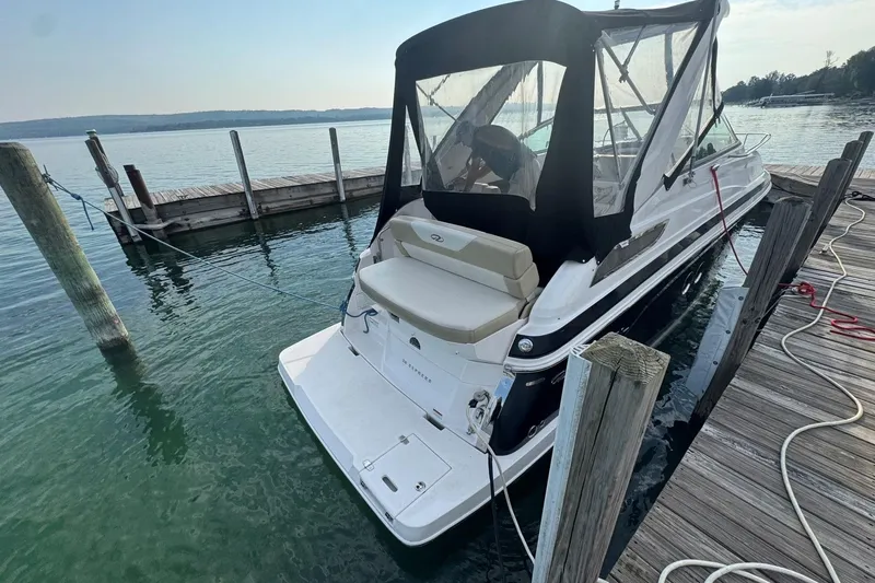 Slide: The Image of 2012 Regal 28 Express boat docked at a serene lakeside pier. - 3