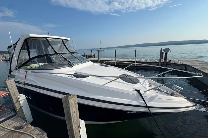 Slide: The Image of 2012 Regal 28 Express boat docked at a serene lakeside marina. - 4