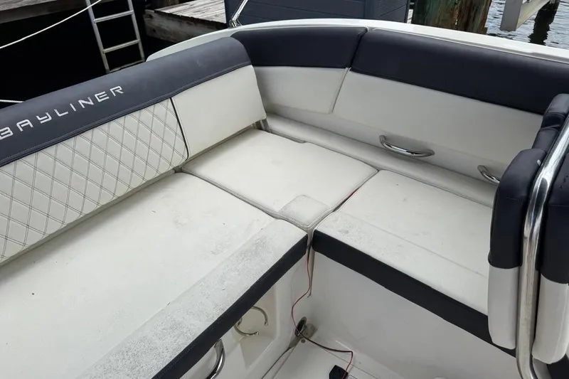 Slide: The Image of Bayliner DX2200 2020 boat interior with cushioned seating and stainless steel handles. - 17