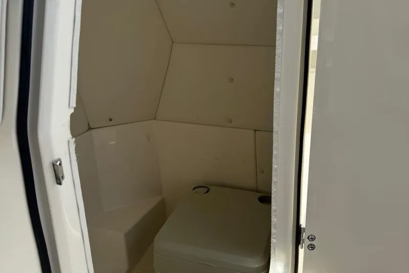 Slide: The Image of Interior of a 2020 Bayliner DX2200 boat, featuring a compact marine toilet. - 6