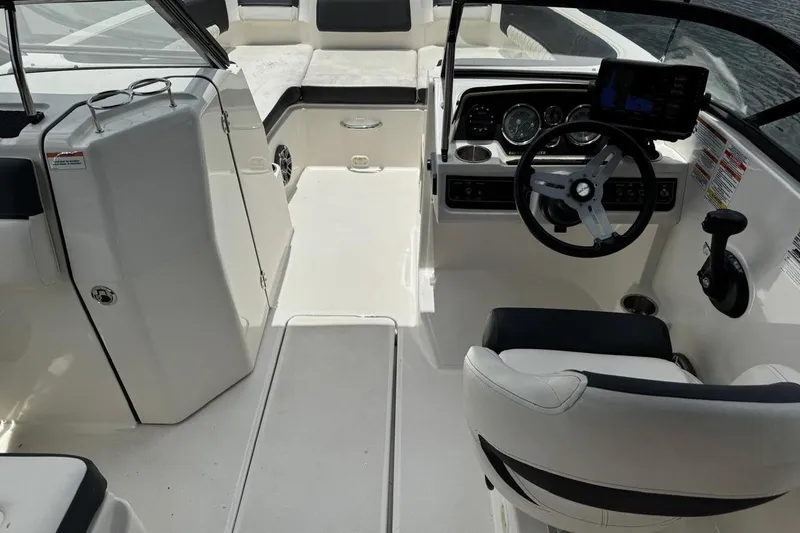 Slide: The Image of Interior view of a 2020 Bayliner DX2200 boat, featuring steering wheel and seating area. - 8