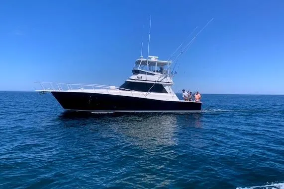 The Image of 1988 Viking 45 Convertible yacht cruising on open sea under clear blue sky. - 0