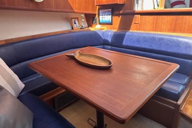 Slide: The Image of 1988 Viking 45 Convertible yacht interior with wooden table and blue seating. - 11