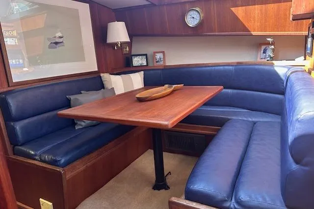 Slide: The Image of 1988 Viking 45 Convertible yacht interior with blue leather seating and wooden table. - 12