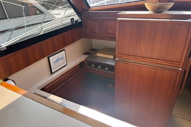 Slide: The Image of 1988 Viking 45 Convertible yacht interior with wooden cabinetry and compact kitchen area. - 15