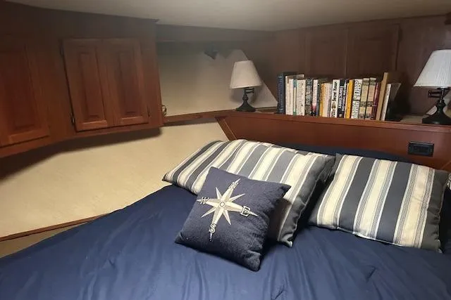 Slide: The Image of Cozy cabin interior of 1988 Viking 45 Convertible with bed, pillows, and bookshelf. - 20