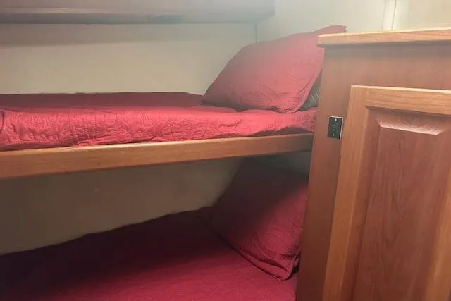 Slide: The Image of Bunk beds with red bedding in a 1988 Viking 45 Convertible yacht cabin. - 23
