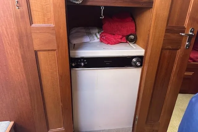 Slide: The Image of Laundry area inside 1988 Viking 45 Convertible boat with wooden cabinetry and towels. - 24
