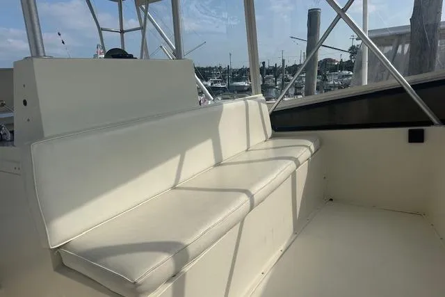 Slide: The Image of 1988 Viking 45 Convertible boat interior with white seating and marina view. - 27