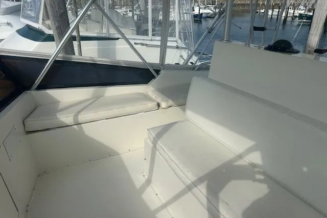 Slide: The Image of 1988 Viking 45 Convertible boat interior with white seating and marina view. - 28