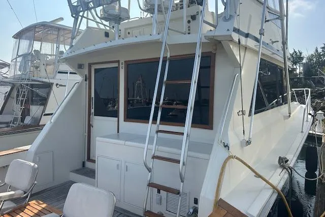 Slide: The Image of 1988 Viking 45 Convertible yacht docked, featuring spacious deck and ladder access. - 3