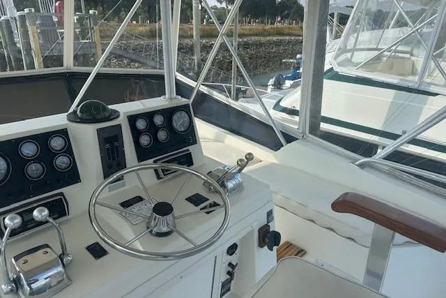 Slide: The Image of 1988 Viking 45 Convertible yacht helm with steering wheel and control panel. - 31
