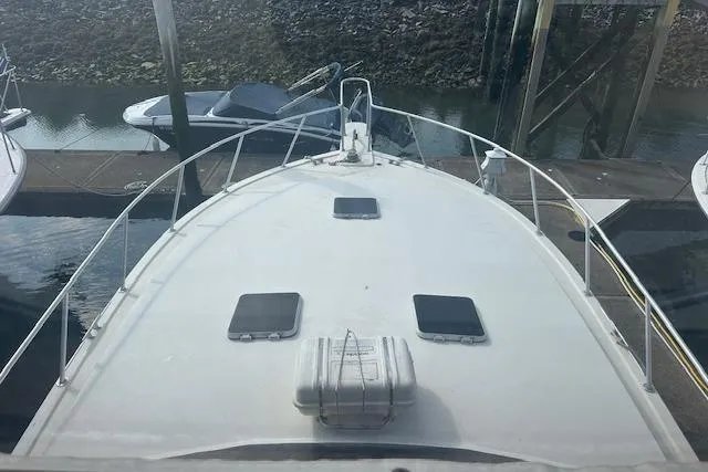 Slide: The Image of 1988 Viking 45 Convertible boat docked, view from the bow, with surrounding watercraft. - 33