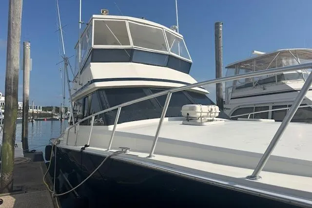 Slide: The Image of 1988 Viking 45 Convertible yacht docked at marina under clear blue sky. - 34