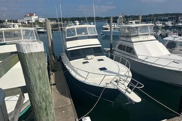 Slide: The Image of 1988 Viking 45 Convertible yacht docked at a marina, surrounded by other boats. - 35