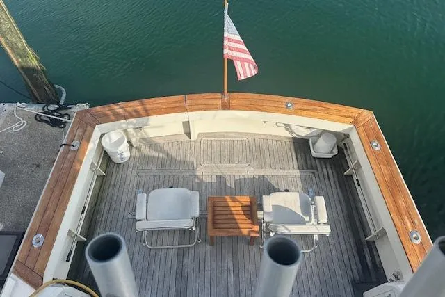 Slide: The Image of 1988 Viking 45 Convertible yacht deck with chairs, table, and American flag. - 36