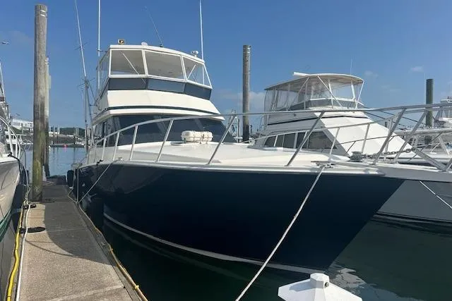 Slide: The Image of 1988 Viking 45 Convertible yacht docked at marina under clear blue sky. - 4