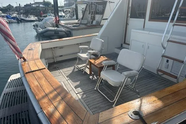 Slide: The Image of 1988 Viking 45 Convertible yacht deck with chairs and table, docked in a marina. - 5