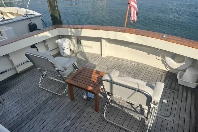 Slide: The Image of 1988 Viking 45 Convertible yacht deck with chairs and table, overlooking water. - 7