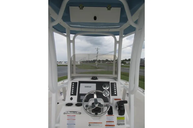 Slide: The Image of 2026 Robalo R222 Center Console boat dashboard with steering wheel and navigation system. - 13