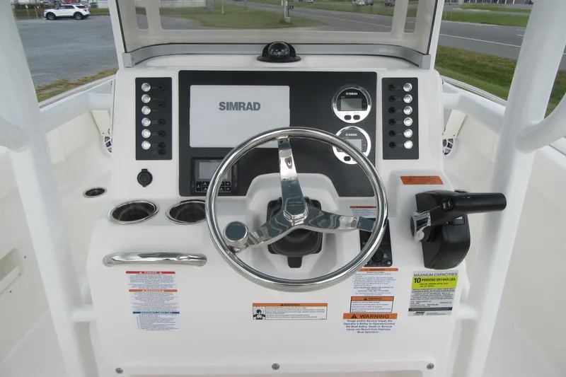 Slide: The Image of 2026 Robalo R222 Center Console boat dashboard with Simrad display and controls. - 14