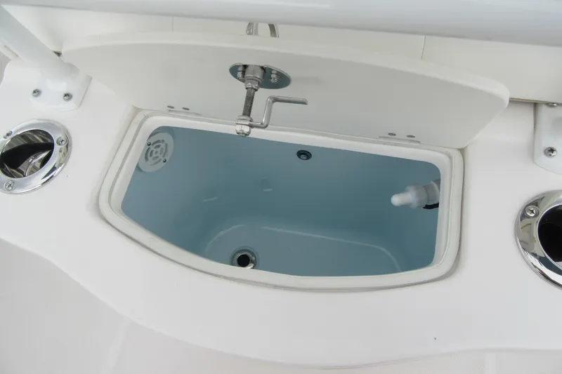 Slide: The Image of 2026 Robalo R222 Center Console livewell with open lid and chrome fittings. - 18
