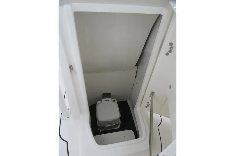 Slide: The Image of 2026 Robalo R222 Center Console boat storage compartment with portable toilet. - 8
