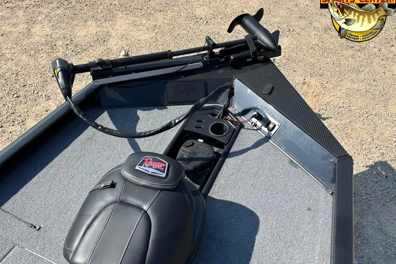 Slide: The Image of 2024 Ranger RT178 boat deck with seat and trolling motor, on gravel surface. - 7