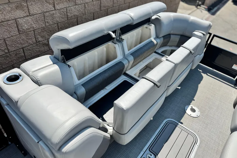 Slide: The Image of 2023 Regency 250 LE3 pontoon boat interior with open storage compartments and seating. - 11