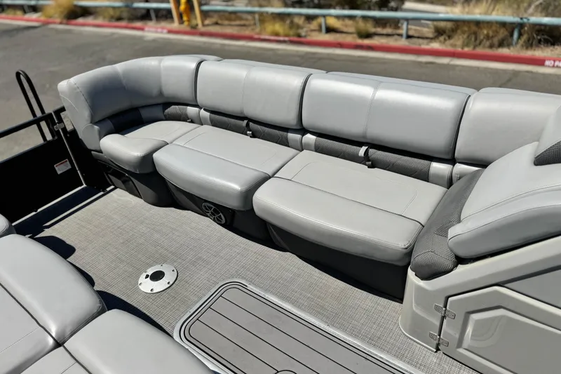 Slide: The Image of 2023 Regency 250 LE3 boat interior with plush gray seating and carpeted flooring. - 12
