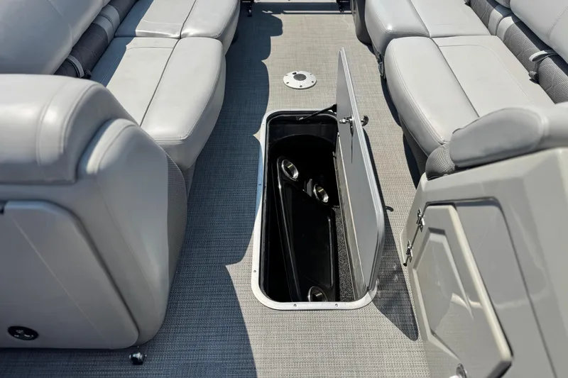 Slide: The Image of 2023 Regency 250 LE3 boat interior with open storage compartment and gray seating. - 13