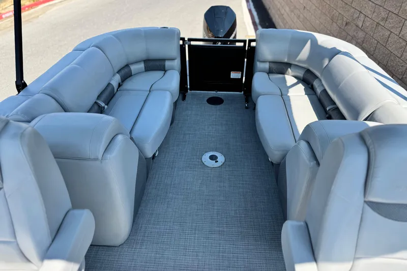 Slide: The Image of 2023 Regency 250 LE3 pontoon boat interior with plush gray seating and spacious layout. - 16