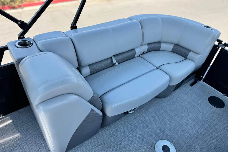 Slide: The Image of Luxurious seating on 2023 Regency 250 LE3 boat, featuring plush gray upholstery and cup holders. - 17