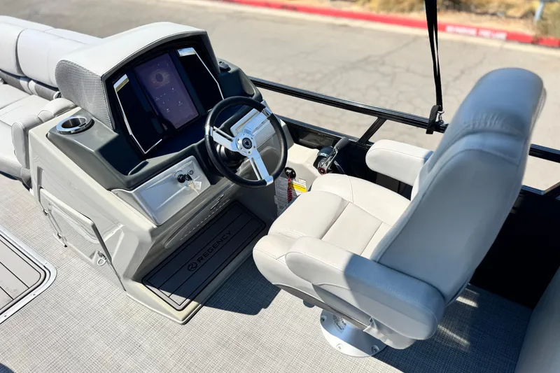 Slide: The Image of 2023 Regency 250 LE3 boat helm with steering wheel and captain's chair. - 21