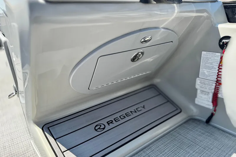 Slide: The Image of 2023 Regency 250 LE3 boat interior with branded flooring and storage compartment. - 25