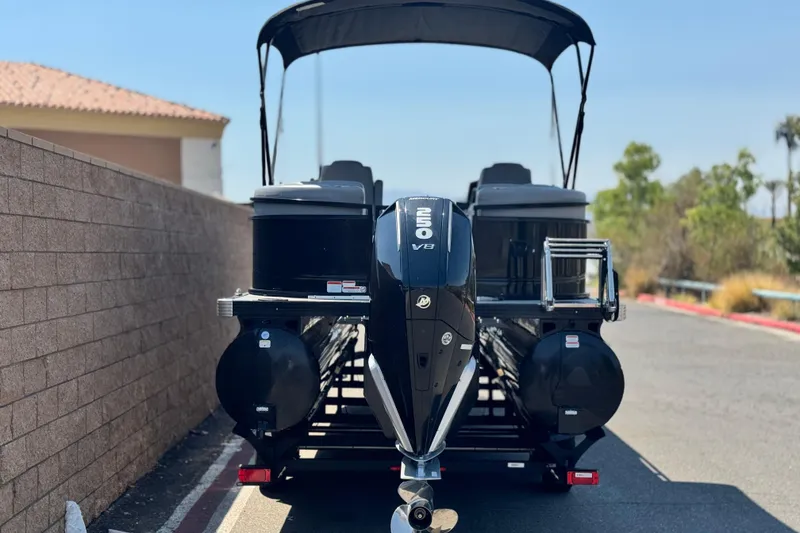 Slide: The Image of 2023 Regency 250 LE3 pontoon boat with V8 engine, parked outdoors. - 5