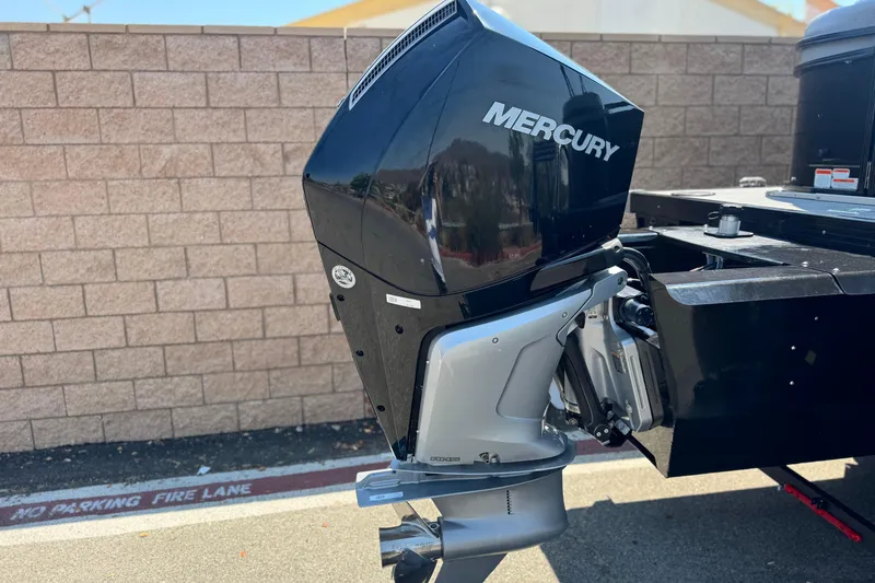 Slide: The Image of 2023 Regency 250 LE3 boat with Mercury outboard motor, parked near a brick wall. - 7
