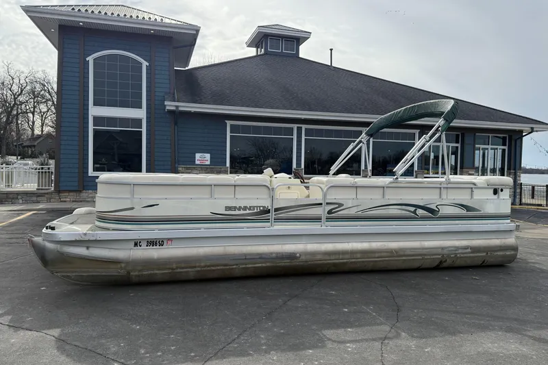 The Image of 2001 Bennington 2550 RL pontoon boat parked outside a blue building. - 0