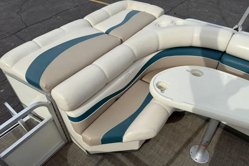 Slide: The Image of Bennington 2550 RL 2001 boat interior with beige and teal seating, table, and cup holders. - 12