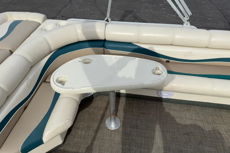 Slide: The Image of Bennington 2550 RL 2001 boat interior with cushioned seating and table. - 13