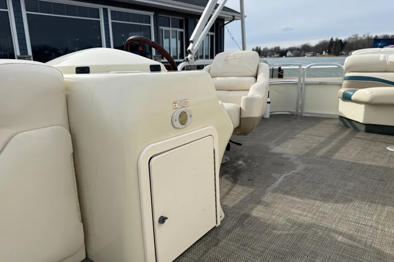 Slide: The Image of 2001 Bennington 2550 RL boat interior with beige seating and steering console. - 16
