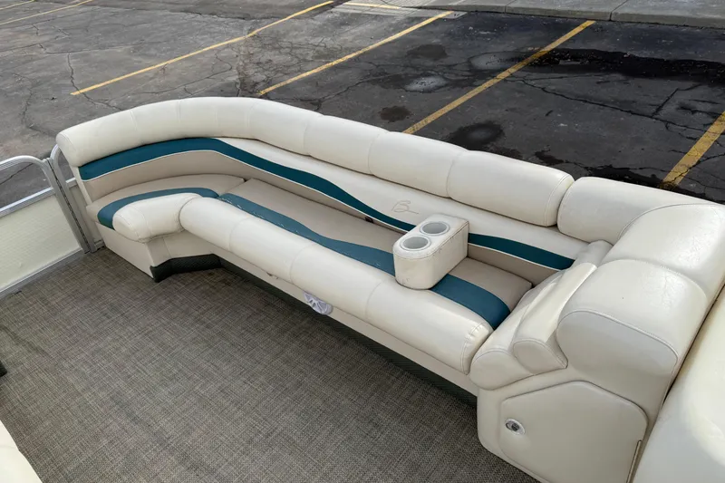 Slide: The Image of 2001 Bennington 2550 RL boat interior with white and teal seating, cup holders, and carpeted floor. - 17