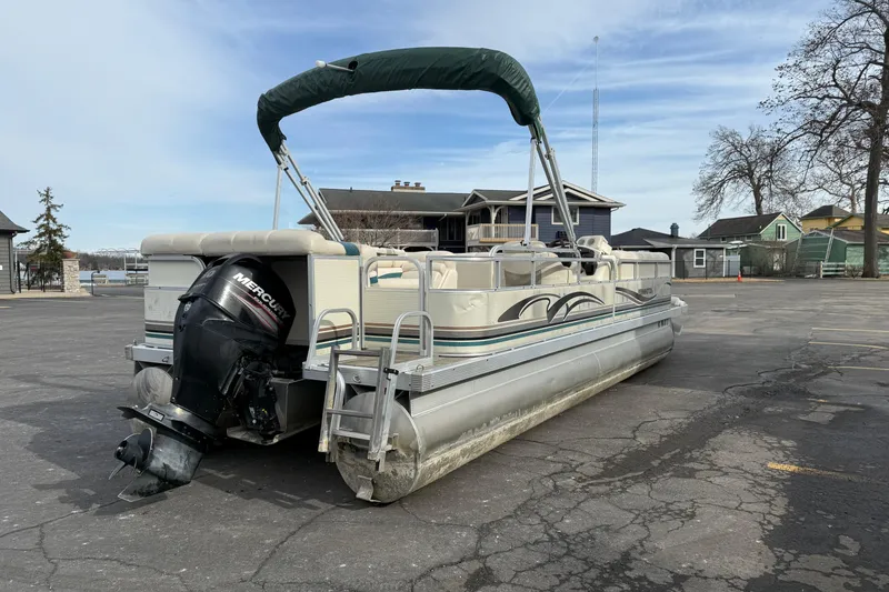 Slide: The Image of 2001 Bennington 2550 RL pontoon boat with Mercury outboard motor in a parking lot. - 6