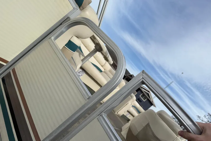 Slide: The Image of 2001 Bennington 2550 RL pontoon boat with beige seating and metal railing under blue sky. - 8