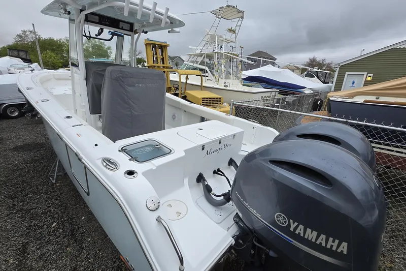 Slide: The Image of 2020 Sea Hunt Gamefish 25 boat with dual Yamaha engines, docked in a marina. - 11