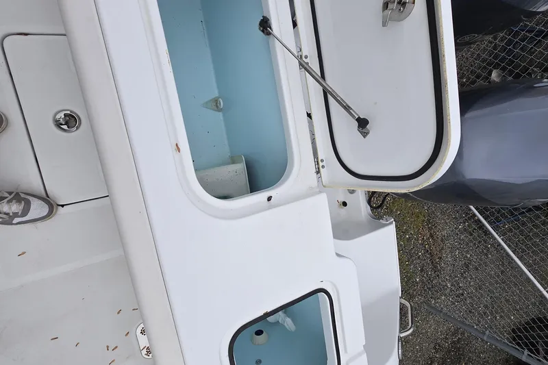 Slide: The Image of 2020 Sea Hunt Gamefish 25 boat with open storage compartments and visible engine. - 12