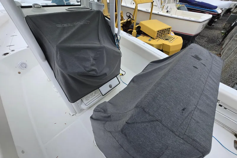 Slide: The Image of 2020 Sea Hunt Gamefish 25 boat interior with protective covers, docked near other boats. - 24
