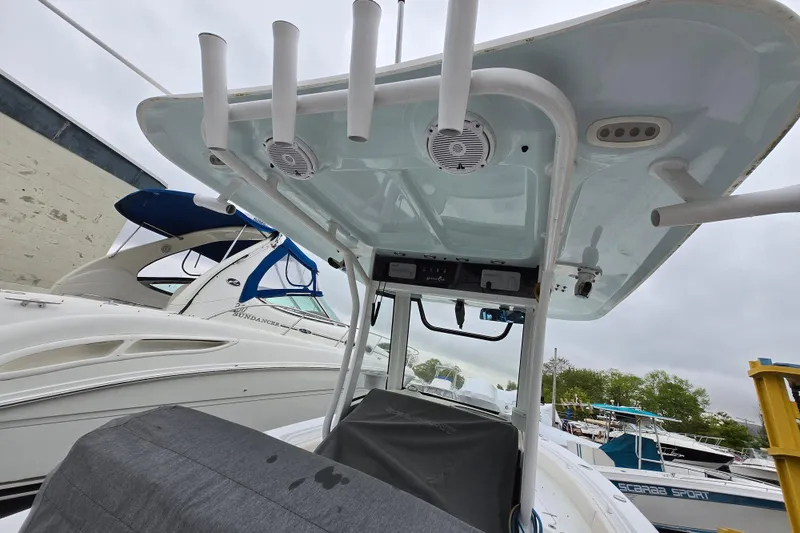Slide: The Image of 2020 Sea Hunt Gamefish 25 boat with T-top and rod holders, docked near other boats. - 26