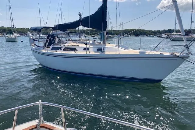 Slide: The Image of 1987 Catalina 30 MK II sailboat anchored in a sunny harbor. - 1