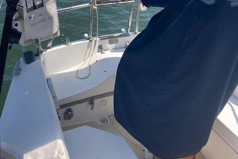 Slide: The Image of 1987 Catalina 30 MK II sailboat cockpit with blue cover and railing, on calm water. - 13